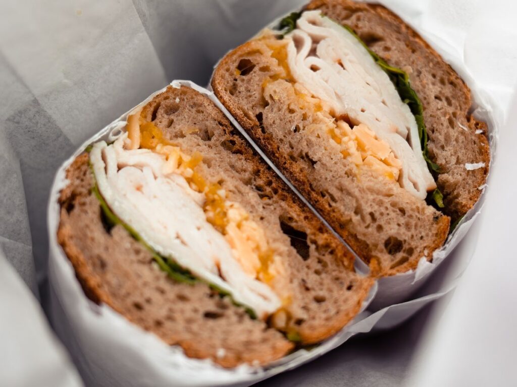 Turkey, hummus, and veggie wrap sliced in half and wrapped for lunch