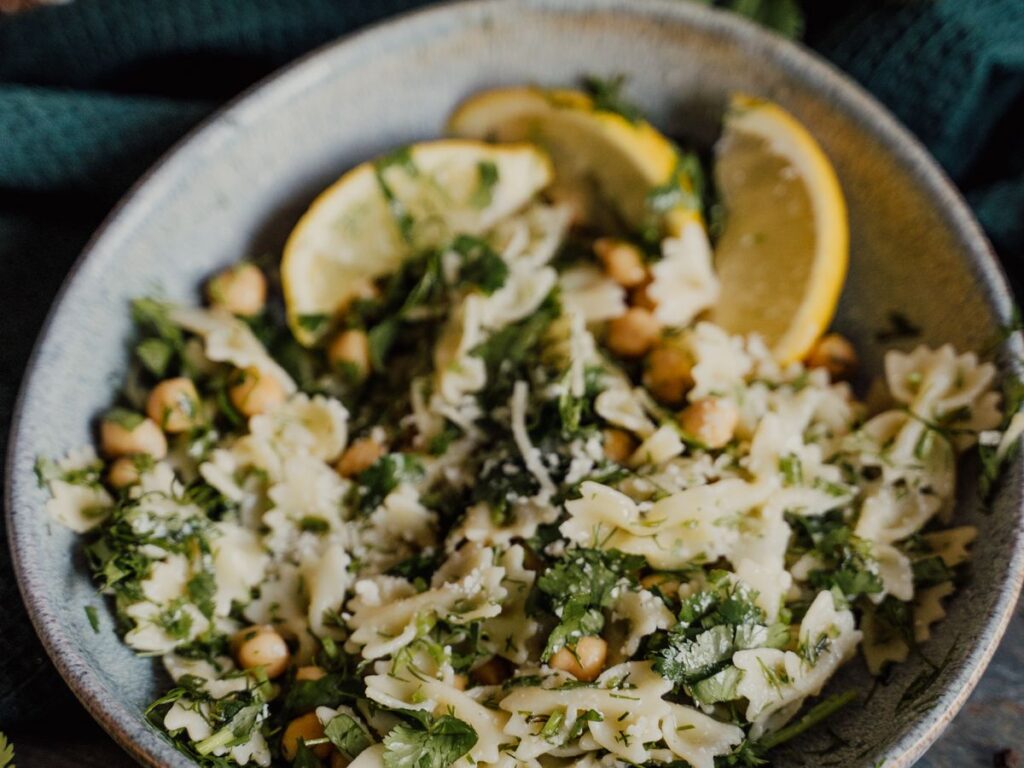 Chickpea pasta salad with parmesan, lemon, and fresh herbs in a bowl
