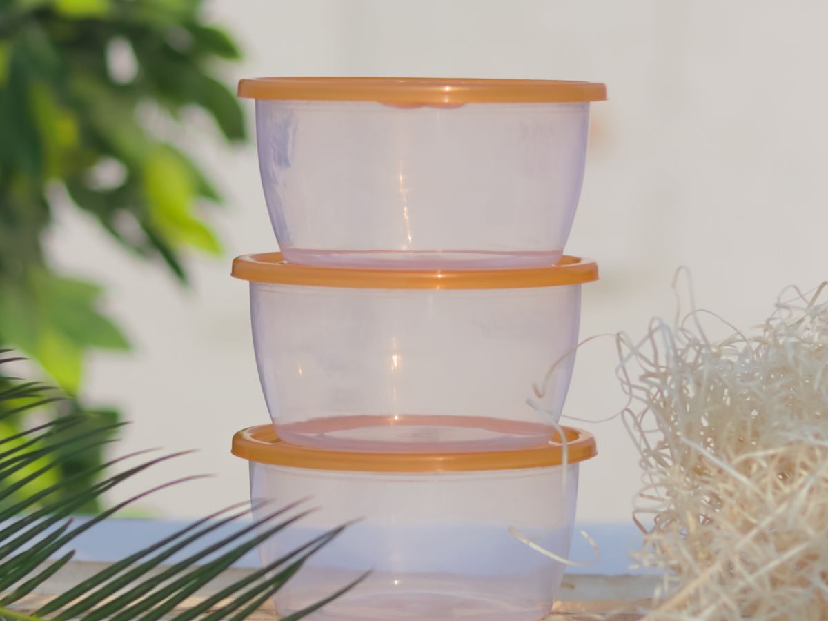Stack of round plastic food containers with orange lids, showing the type of leak-proof seal to look for in meal prep containers