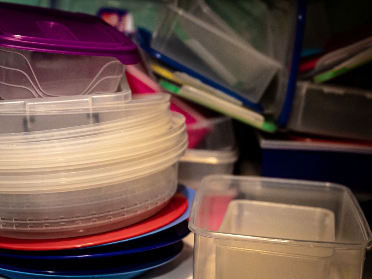 Mismatched plastic food containers and lids stacked together, illustrating why the right meal prep containers matter